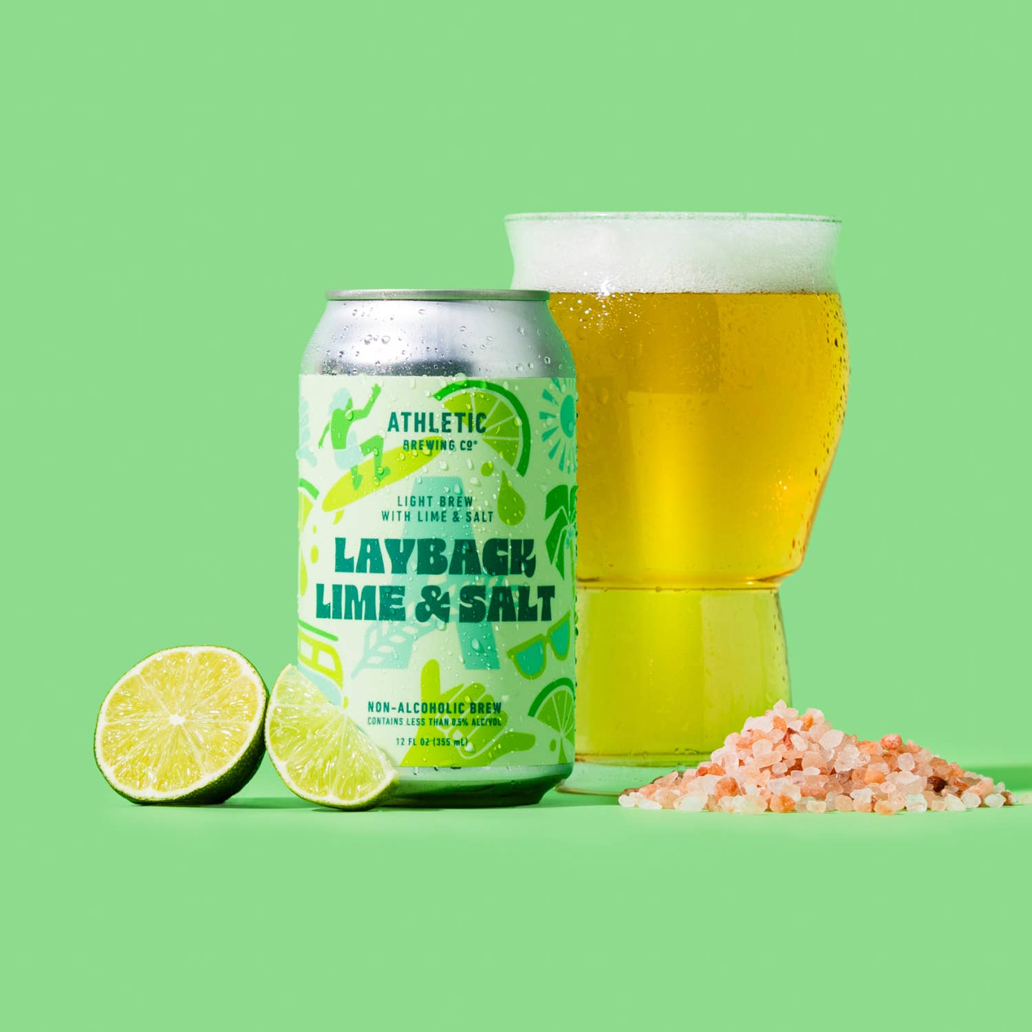 Athletic Brewing Co. Layback Lime & Salt non-alcoholic beer can with a glass of beer on a green background.
